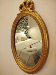 a mirror on a wall with a bed in a room at Cuore Barocco in Noto