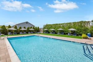 a swimming pool with chairs and umbrellas at The Ocean Resort Inn in Montauk