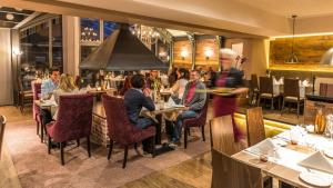 un grupo de personas sentadas en mesas en un restaurante en Stratmanns Hotel, en Lohne