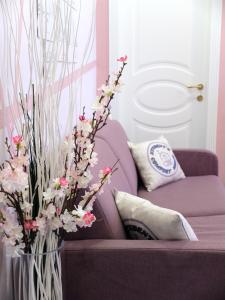 un sofá púrpura con un jarrón lleno de flores en Turin Comfort Home en Turín