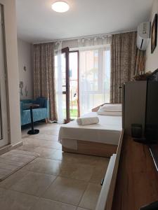 a bedroom with a bed and a television in it at Megi Apartments, Nesebar sity in Nesebar