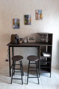 a desk with two stools in front of a wall at Casa Vacanze Dolce Vita in Termoli