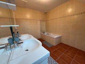 ein Badezimmer mit zwei Waschbecken und einer Badewanne in der Unterkunft Maison familiale spacieuse -Château de Chambord in Huisseau-sur-Cosson