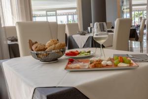 a table with a plate of food and a glass of wine at Hotel Continental in Caorle