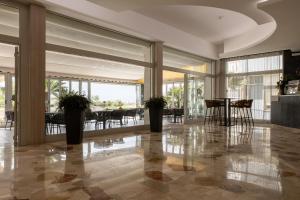 a lobby with a table and chairs and glass doors at Hotel Continental in Caorle