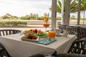a table with a plate of food and a drink at Hotel Continental in Caorle