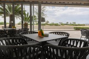 a table and chairs in a restaurant with a window at Hotel Continental in Caorle