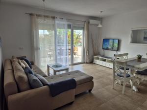 a living room with a couch and a table at Apartment Perla in Dinjiška