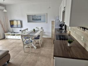 a kitchen and living room with a table and chairs at Apartment Perla in Dinjiška +7 photos
