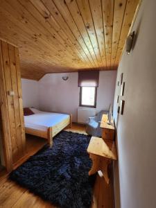 a bedroom with a bed and a wooden ceiling at Chalet Luna Parang in Petroşani