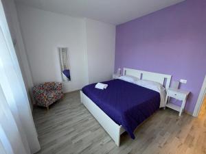 Dormitorio púrpura con cama y silla en Villa Vittoria, en Stresa