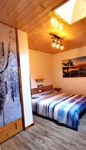 ein Schlafzimmer mit einem großen Bett in einem Zimmer in der Unterkunft Trilocale mansardato nel cuore della Val Di Fiemme in Ziano di Fiemme