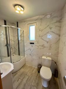 a bathroom with a toilet and a tub and a sink at Słonecznikowa Dolina in Sarbinowo +26 photos