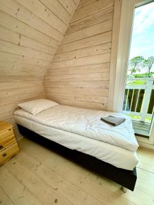 łóżko w pokoju z drewnianą ścianą w obiekcie Słonecznikowa Dolina w Sarbinowie