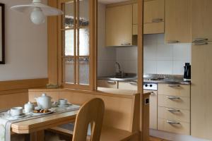 a kitchen with a stove top oven and a sink at Apartments Boè in Santa Cristina Gherdëina