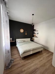 ein Schlafzimmer mit einem Bett und einer schwarzen Wand in der Unterkunft Apartment Rose Pula in Pula