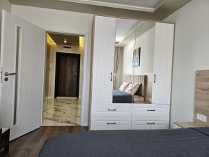 a bedroom with a bed and a large mirror at AMORA Apartment in Dobrich