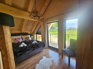 a bedroom with a bed and a window and a chair at Alpen House in Dursztyn +12 photos