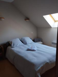 1 dormitorio con cama con sábanas azules y ventana en Les Baillis, en Villegenon
