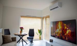 a living room with a large tv and a table at Imperial Citi Yes Apartament in Krakow