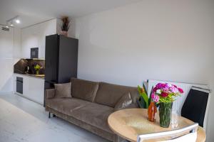 a living room with a couch and a table with flowers at Imperial Citi Yes Apartament in Krakow