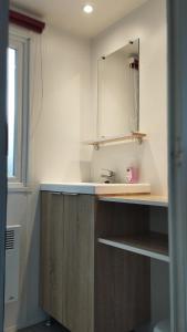 a kitchen with a sink and a mirror at LJ Cosy Lodge - Mobilhome in Houlgate
