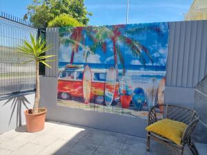 une peinture de planches de surf sur un mur avec une chaise dans l'établissement Beach life Caparica, à Costa da Caparica
