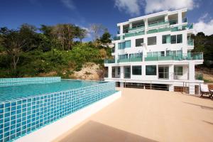 a house with a swimming pool next to a building at The Baycliff Residences in Patong Beach