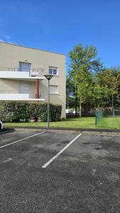 un aparcamiento vacío frente a un edificio en Bel appartement F3 tout confort, en Saint-Vincent-de-Paul
