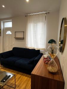 a living room with a blue couch and a table at Charmante maison de ville avec jardin in Le Petit-Quevilly