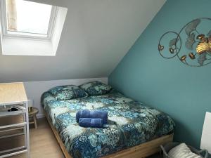 a small bedroom with a bed with blue sheets at Charmante maison de ville avec jardin in Le Petit-Quevilly