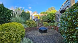een tuin met een tafel op een bakstenen patio bij The Bank - Period Cottage in Picturesque Village 