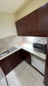 a small kitchen with a sink and a microwave at 100 Service suites At Times Square KL in Kuala Lumpur