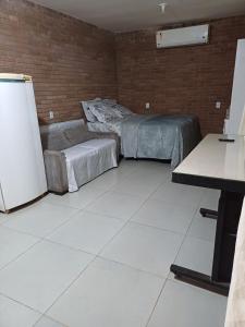 a room with two beds and a refrigerator at Casa aconchegante in Bragança Paulista
