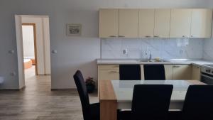 Apartment Diana - Novalja في نوفاليا: مطبخ مع طاولة وكراسي ومغسلة