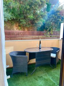 a table with two chairs and a bottle of wine at Sa Boadella - Fenals Beach in Lloret de Mar