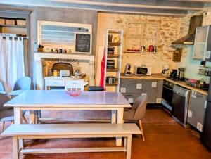 una cucina con tavolo al centro di una stanza di Le Cottage de Laugère - Gite avec piscine a Charenton sur Cher Altre 14 foto
