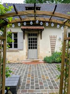 una casa con pergolato in legno e patio di Le Cottage de Laugère - Gite avec piscine a Charenton sur Cher