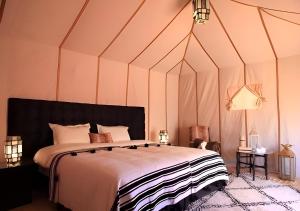 a bedroom with a large bed in a tent at Merzouga Top Desert Camp in Merzouga