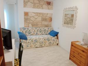 un soggiorno con un divano e uno specchio di Appartamento bilocale ERICA a Monteriggioni