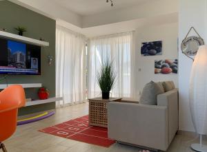 sala de estar con sofá y TV en Villa Evita , penthouse, 53m2 ,Athytos 450m from the beach, en Afitos