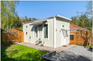 cobertizo blanco pequeño con terraza de madera en Fresh happy little house, 35 m2 IN Täby en Estocolmo