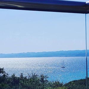 vistas a un lago con un barco en el agua en Villa Evita , penthouse, 53m2 ,Athytos 450m from the beach, en Afitos