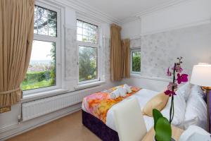 1 dormitorio con 1 cama y 2 ventanas en Phoenix Rise Retreat, en Glastonbury