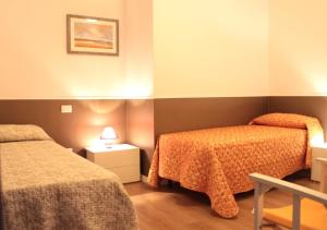 チヴィタノーヴァ・マルケにあるPino Marittimoのベッド2台とナイトスタンド付きのホテルルームです。