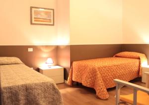 a hotel room with two beds and a night stand at Pino Marittimo in Civitanova Marche