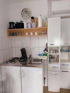 a kitchen with white cabinets and a sink at Ferienhaus Pomerania Bootsmann Koje kleine Auszeit bei Rügen in Sundhagen