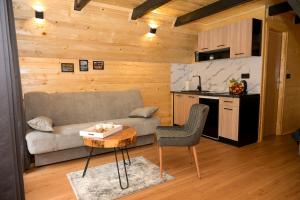 a living room with a couch and a table and a kitchen at Cottage NIKA in Jajce