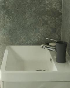 a white toilet with a cup on top of it at A lovely flat in Visoko in Visoko