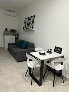 a living room with a table and chairs and a couch at Home Sweet Home in Siracusa